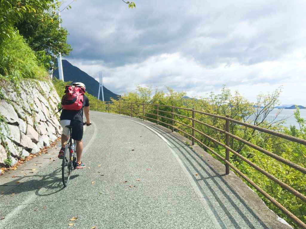 坂道をロードバイクで上る男性